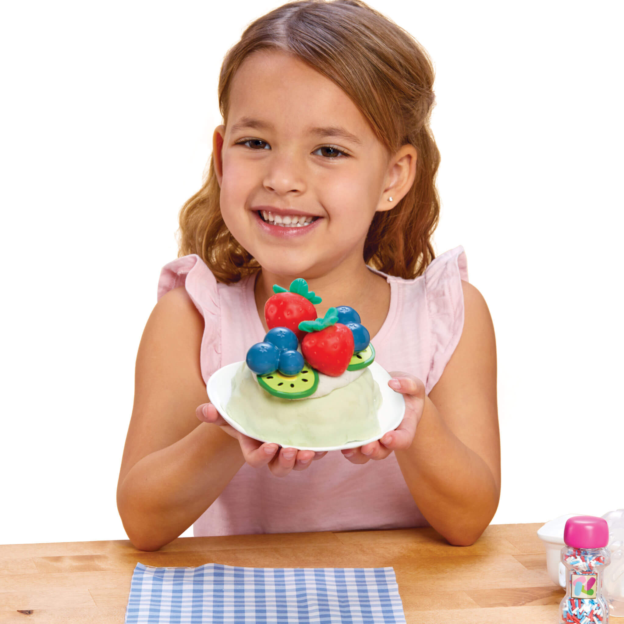 Young girl holding the cake with fruits on a white background